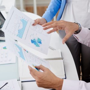 Healthcare consultants analyzing medical practice revenue cycle management charts and analytics reports.